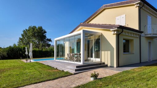 Pergola bioclimatica con vetrate in giardino