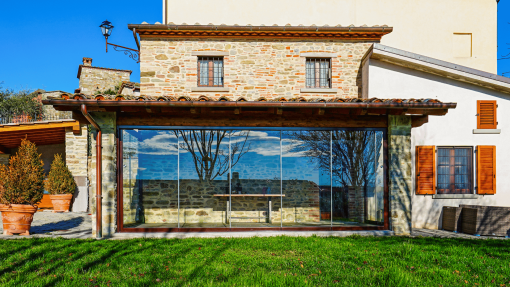 Vetrate panoramiche scorrevoli in un portico con affaccio sul giardino